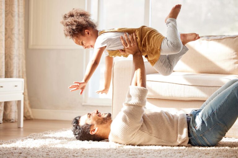 dad and daughter playing on the carpet